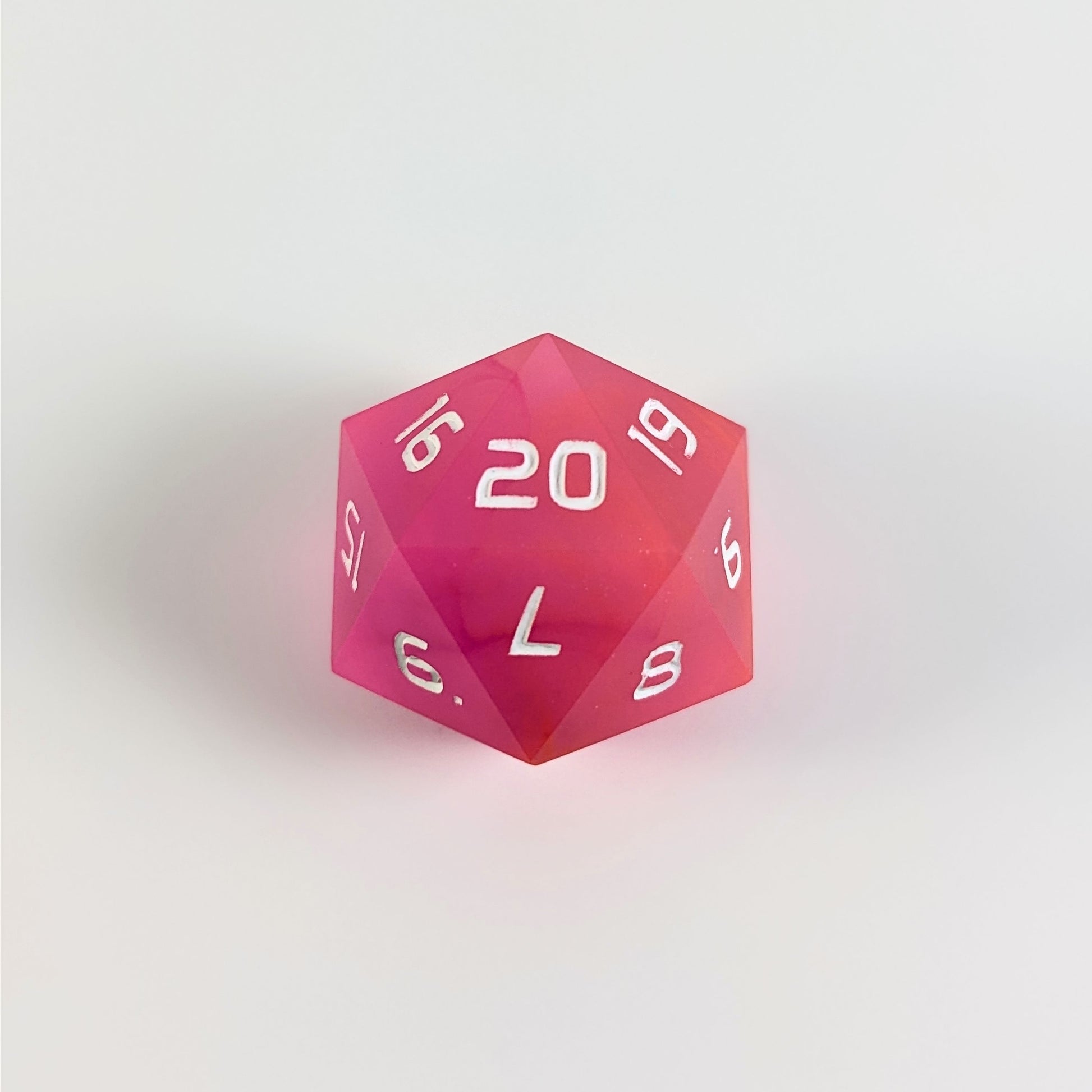 A magenta spindown d20 with white numbers and a right spin sits on a white background with the 20 face up.