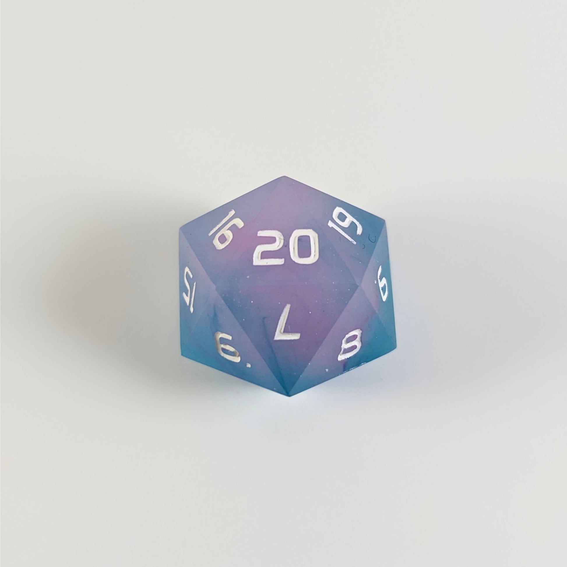 An opaque teal and pink spindown d20 with white numbers and a right spin sits on a white background with the 20 face up.