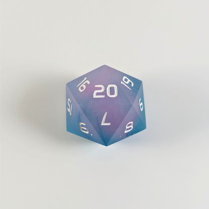 An opaque teal and pink spindown d20 with white numbers and a right spin sits on a white background with the 20 face up.