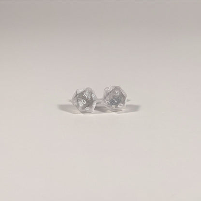 A single pair of the smaller size handmade d20 earrings with titanium hardware that are glittery clear with pink flakies with white numbers on a white background. The earring on the left centers the 20 face and the earring on the right centers the 1 face.