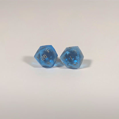 A single pair of the larger size handmade d20 earrings with titanium hardware that are sapphire blue with bronze numbers on a white background. The earring on the left centers the 20 face and the earring on the right centers the 1 face.