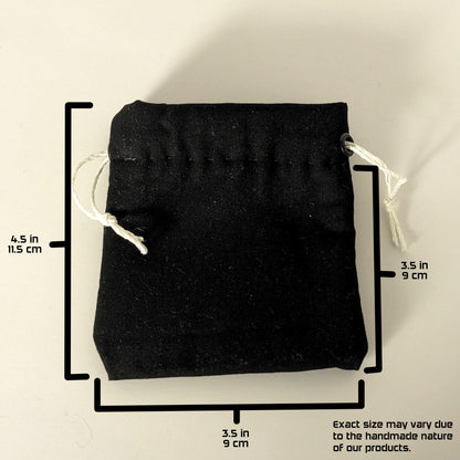 A handmade, black, small size dice bag with white drawstrings lays flat on a white background. The graphic includes overlays showing the full height of the dice bag as 4.5 inches or 11.5 cm, the width of the dice bag as 3.5 inches or 9 cm, and the height from bottom to drawstring as 3.5 inches or 9 cm. A note in the bottom right corner states "Exact size my vary due to the handmade nature of our products."
