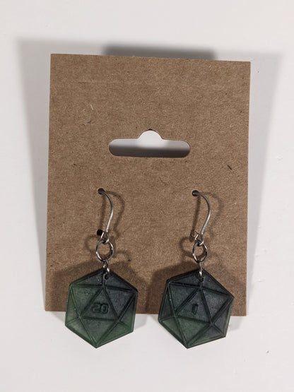 A pair of black and dark green dangly, flat d20 earrings with silver color titanium and niobium hardware on a kraft earring card on a white background. The earring on the left has a 20 on it and the earring on the right has a 1 on it, both in a sci-fi style font.