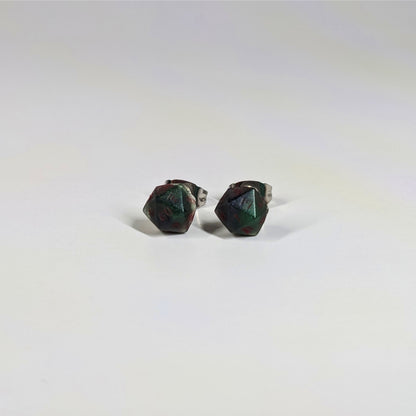 A single pair of the smaller size handmade d20 earrings that are dark green and black with red numbers on a white background. The earring on the left centers the 20 face and the earring on the right centers the 1 face.