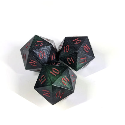 Three handmade reliable talent d20s on a white background. The dice are all black and dark green with red numbers, showing the variety in swirl patterns making each die unique. Faces that would be 9 or below are replaced with a 10.