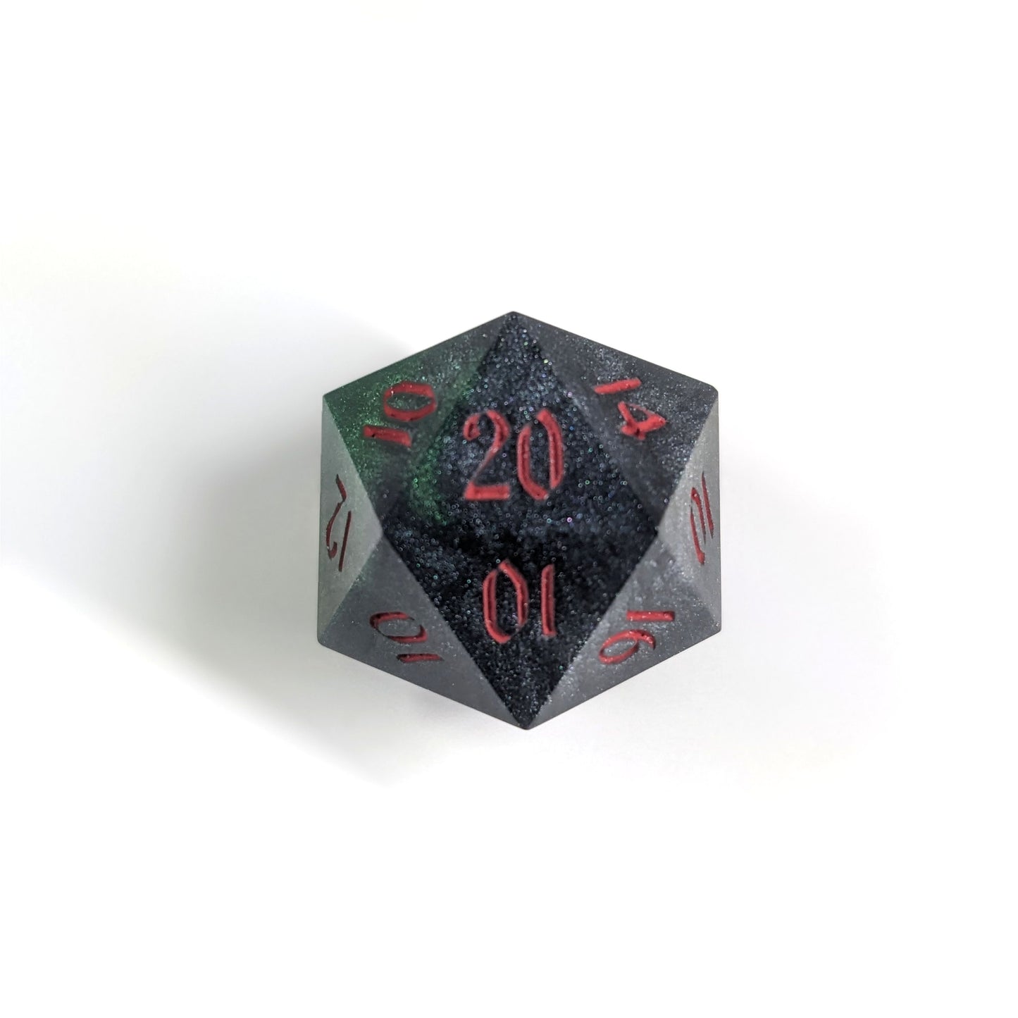 A top down photo of a reliable talent d20 on a white background. The die is black and dark green with red numbers. Faces that would be 9 or below are replaced with a 10.