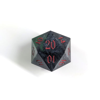 A top down photo of a reliable talent d20 on a white background. The die is black and dark green with red numbers. Faces that would be 9 or below are replaced with a 10.