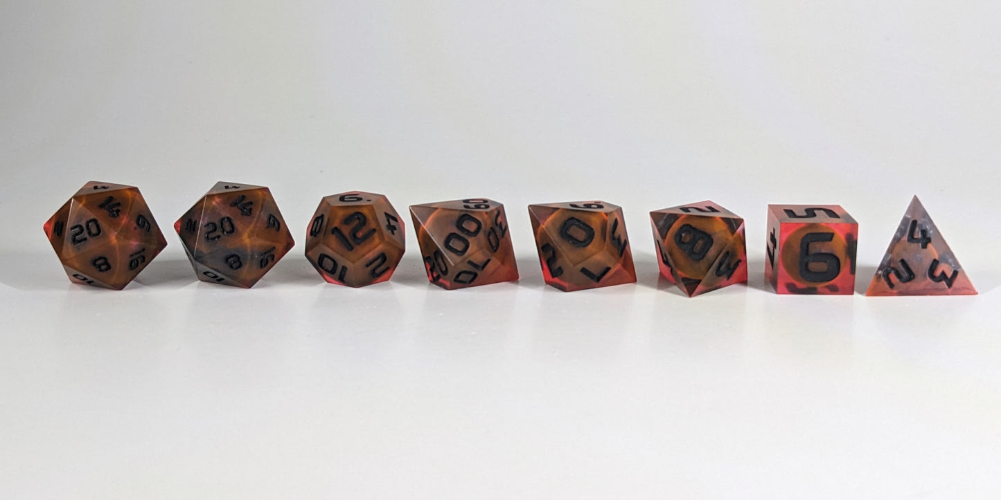 A straight on photo of a complete set of polyhedral dice that are a glowy red-orange with dark spherical inserts and black numbers arranged in a straight line. They are lined up with the 2 d20s on the left going down to the d4 on the right side. The highest value number of each die is facing forward.