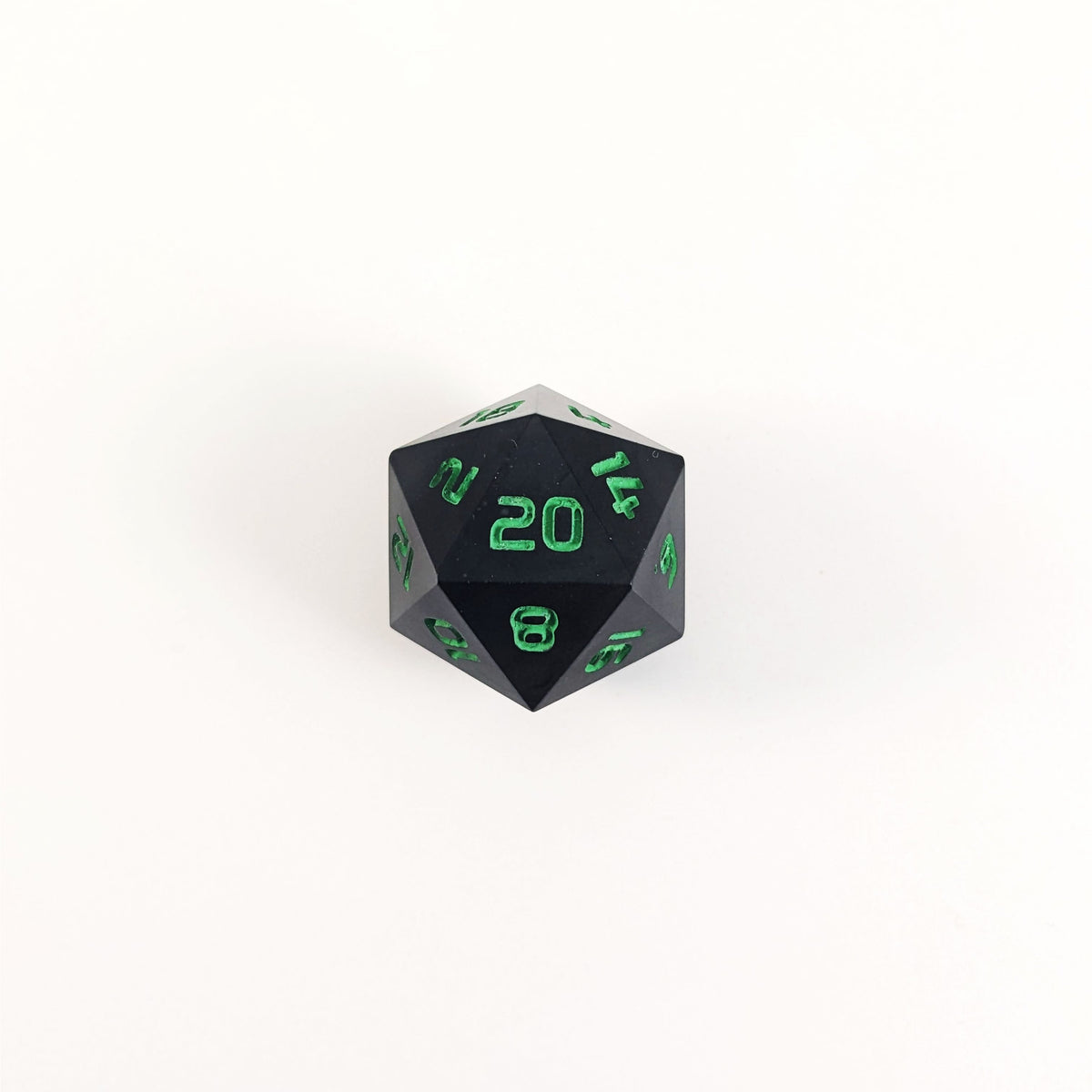 A high angle photo of a standard d20 with black swirls and green numbers with the 20 face up on a white background.
