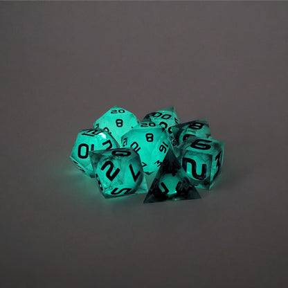 A complete set of 8 polyhedral dice that with spherical inserts glowing green, black swirls and purple numbers, showing the glow-in-the-dark feature of this dice set. The DnD dice set is arranged in a circle and features 2 D20s, one of which is in the center surrounded by the other 7 dice.