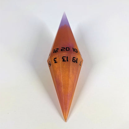 A mid angle shot of a purple and orange diamond d20 with black numbers on a white background.