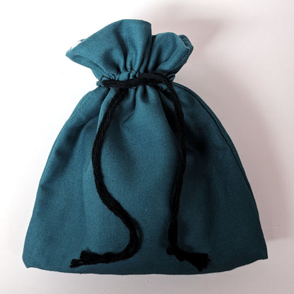 A handmade, teal, medium size dice bag is tied closed by it's black drawstrings.