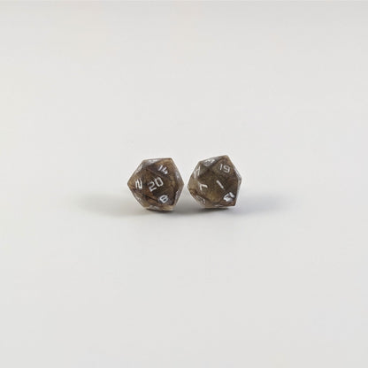 A single pair of the larger size handmade d20 earrings with titanium hardware that are brown and yellow tiger's eye swirls with white numbers on a white background. The earring on the left centers the 20 face and the earring on the right centers the 1 face.