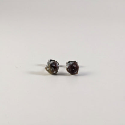 A single pair of the smaller size handmade d20 earrings that are maroon, dark silver, and gold with white numbers on a white background. The earring on the left centers the 20 face and the earring on the right centers the 1 face.