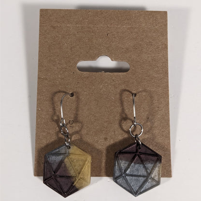 A pair of gold, maroon, and dark silver dangly, flat d20 earrings with silver color titanium and niobium hardware on a kraft earring card on a white background.