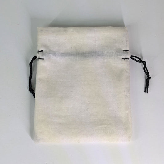 A small, handmade dice bag that is white lays flat on a white background.