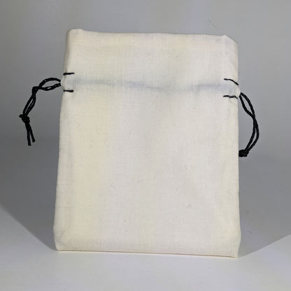 A small, handmade dice bag that is white stands upright on a white background.