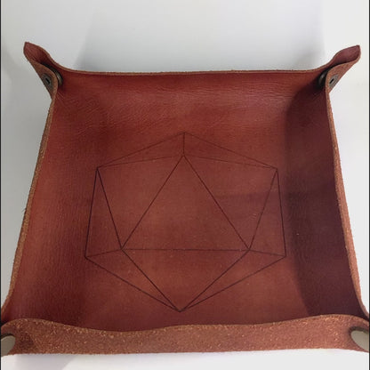 The video starts with a brown leather dice tray in view that has a d20 shape lasered into it. A hand appears from the bottom right corner holding a complete set of polyhedral dice that are purple, pink, and blue swirls with a clear shell with extra glitter and white numbers. The hand rolls all of the dice into the tray from the right.